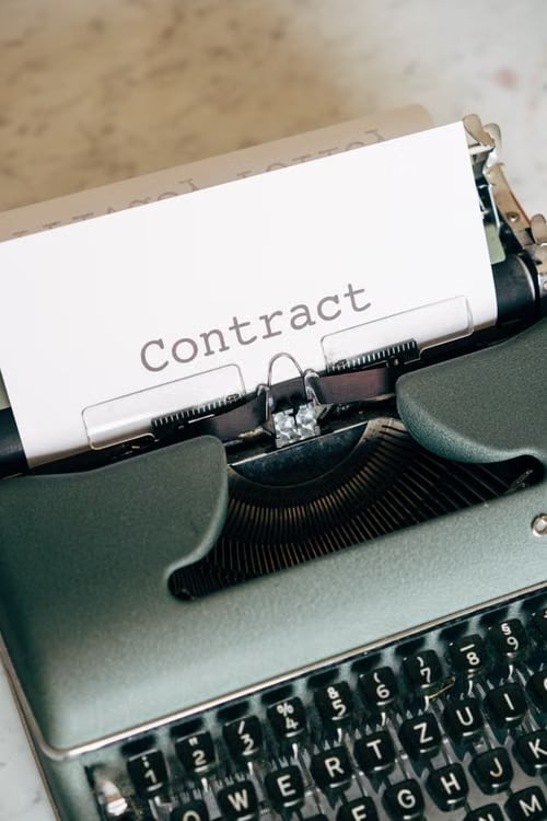 타자기에 걸린 Contract 문서